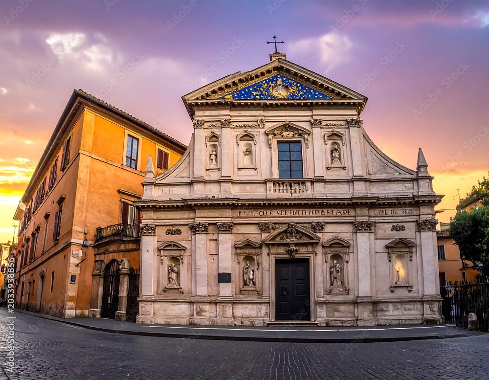 Obraz premium Historic Baroque Church Facade Glowing at Sunset on Quiet Cobblestone Street