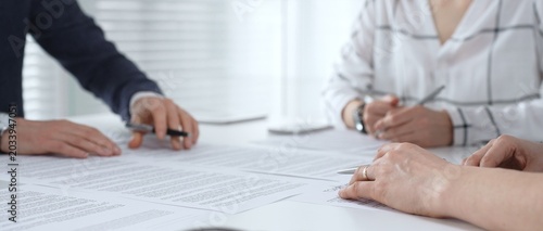 Foto Business people discussing contract documents on a white desk, analyzing clauses