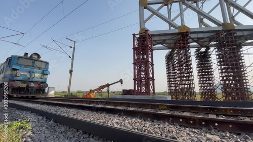 Electric Train Passing Railway Tracks Near High Voltage Substation Infrastructure