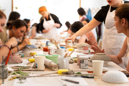 Women learning pottery at a ceramic workshop, creating handmade crafts with friends