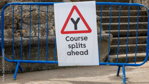 Course Split Warning Sign on Metal Barrier

