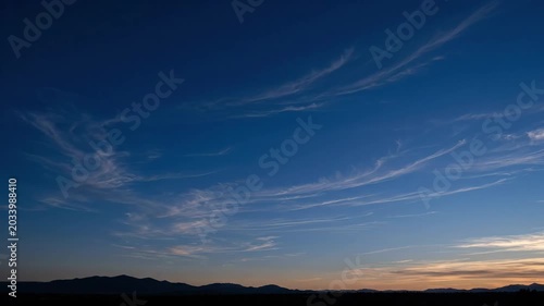 Deep blue evening sky holds delicate cirrus streaks above fading light, serene natural backdrop for minimalist design and copy space, premium abstract or commercial background, strong copy space and