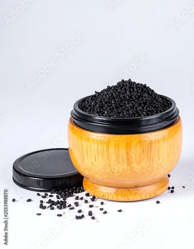 Heap of Tiny Black Seeds in Round Wooden Bowl on White Background