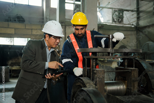 Photos Professional manager with tablet instructing and mentoring an industrial machine