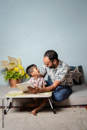 Father and Son Reading Together on a Bed, Learning and Bonding in a Cozy Home Environment