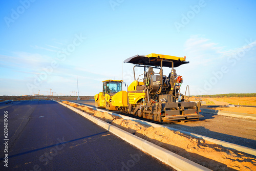 Asphalt road construction. Vibrator compactor machine on roadworks, asphalt pavement. Asphalt paving installation. Road roller on road construction. Vibration roller on highway asphalting. Road Constr