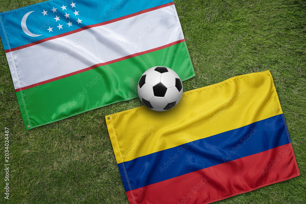 Fototapeta premium Uzbekistan and Colombia flags with a soccer ball on a green grass field a patriotic sports composition national football equipment nationalism international