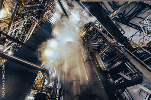 Foto Industrial pipes and steel tanks with rising steam
