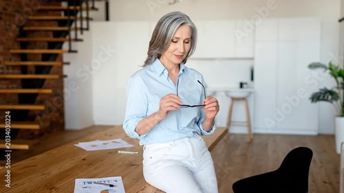 Successful mature businesswoman smiling in a modern home office