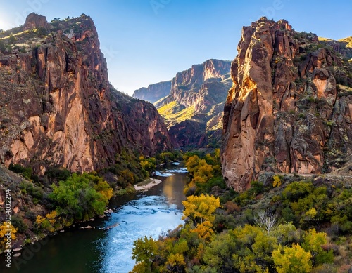 Dramatic Rocky Canyon Framing Winding River in Sunlit Mountain Valley