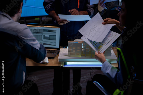 Obraz na plátně Engineering and business professionals discussing architectural building model