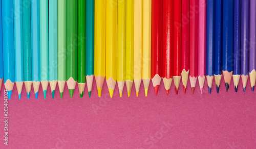 Multicolored wooden pencils in a row, drawing and creativity tools, close up
