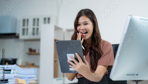 Fotografia Overjoyed, Asian female businessman celebrates a financial bonus.