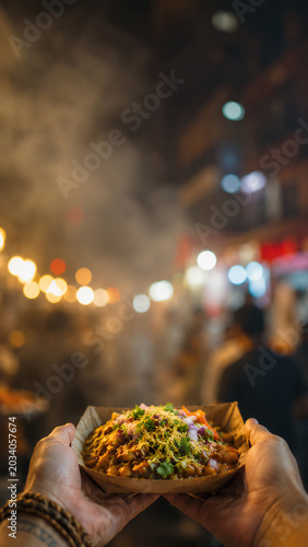 Vertical POV Hands Receiving Street Food with Blurred Night Market Background