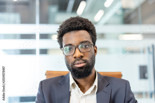 Fotografie Professional businessman with a beard and eyeglasses sitting in an office environment