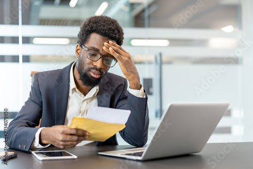 фотографія Stressed businessman in a modern office receiving bad news in a letter, experien