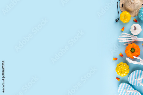 Summerween holiday background. Bright festive background for summer Halloween holiday in style of Halloween with summer decorations, pumpkins, ghost, bat, summer vacation accessories, tropical leaves