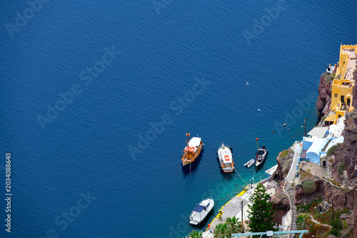Schilderij op canvas Tour boats beneath Fira caldera cliffs