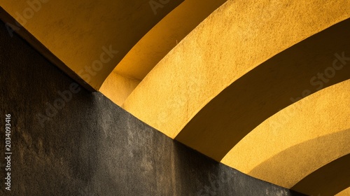 Captivating geometric patterns create a striking contrast between shadows and vibrant yellow tones, evoking a sense of modern architecture and artistic flair in urban settings.