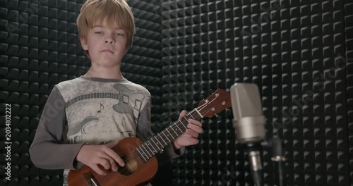 Boy Play Music on Ukulele Instrument in Home Studio. 4K 10-bit