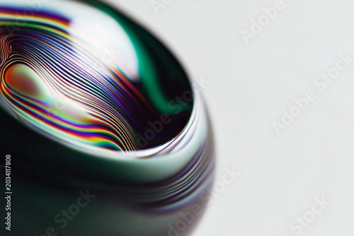 Colorful swirling lines create abstract patterns on a rounded surface.