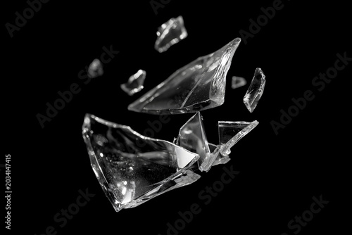 Obraz na plátne Flying broken glass shards isolated on a black background, with sharp transparent fragments, glossy reflections, and dramatic studio lighting