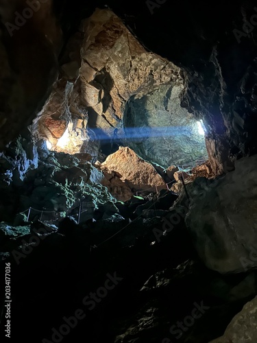 Gigantesca cueva con un rayo de sol que entra por la entrada e ilumina el interior