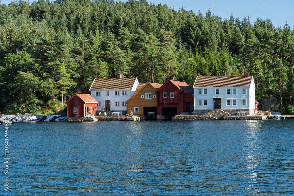 Fototapeta premium Scandinavian harbor community with colorful waterfront houses, small marina and quiet coastal village atmosphere near Lindesnes Lighthouse in Norway for tourism and Nordic living