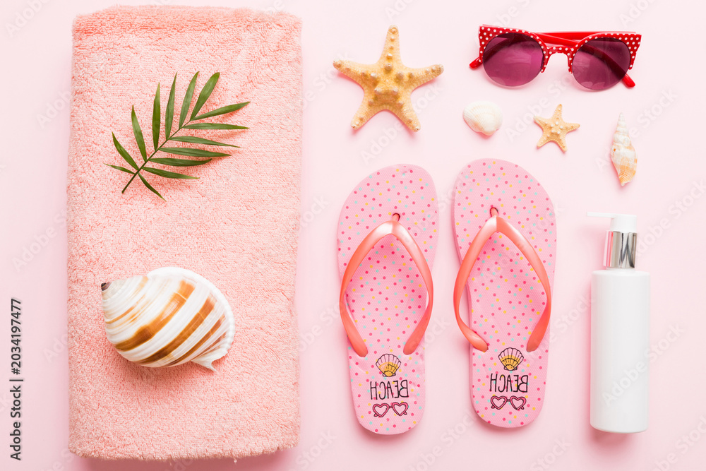 Fototapeta premium Summer holiday concept. Top view of beach towel, flip flop and sunscreen cream on table Top view with copy space for text