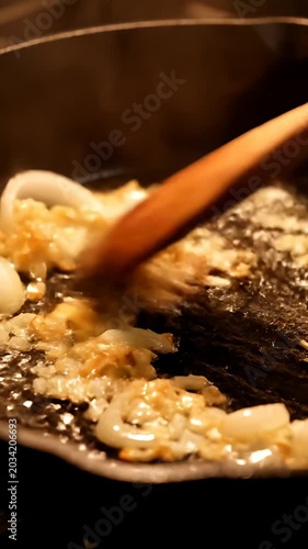 Chopped garlic and onions sizzling in hot oil.