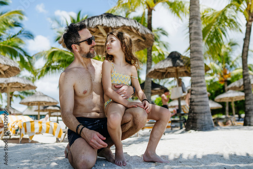 Father with young daughter in beach resort.
