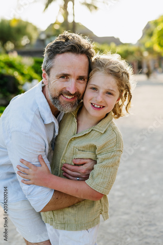 Father with young son in tropical beach resort.