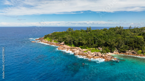 Turquoise waters and white sand beaches are framed by forested cliffs and rocky outcrops. La Digue, Seychelles.