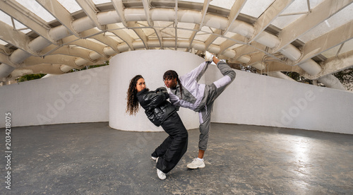 Foto Young female dancers posing in artistic freestyle urban dance against a striking
