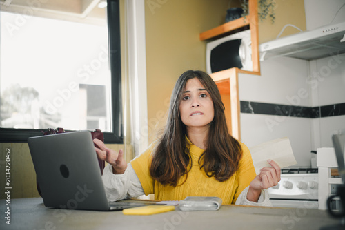 Canvas-taulu Young Hispanic woman feeling frustrated and stressed about not being able to pay household debts