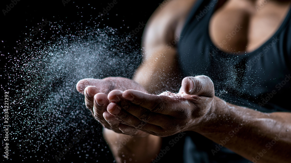 Fototapeta premium Athletic woman clapping hands with chalk powder creating dynamic fitness training and strength workout concept