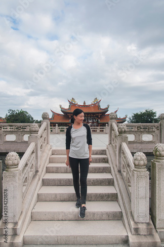 A chinese woman standing on steps inside the A-ma Cultural Village