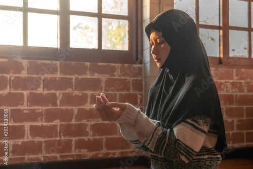 Foto Muslim woman wearing hijab sitting and pray in the room