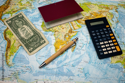 Photos ravel planning concept with passport, calculator, one dollar bill and pen on wor