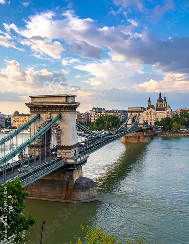 Iconic suspension bridge over river, city skyline