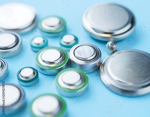 Close-up of Various Button Cell Batteries on a Blue Surface.