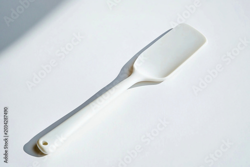White silicone spatula on white background with soft shadows