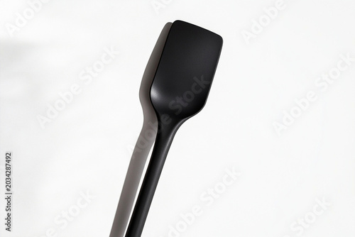 Black spatula on white background with shadow