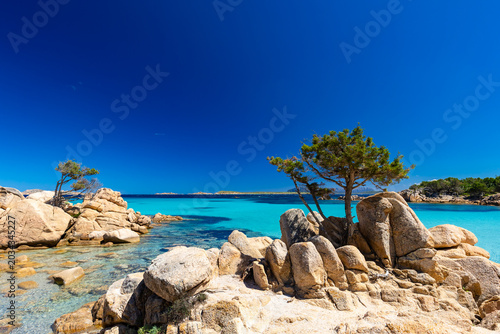 Rocky coastline with turquoise sea, white sand beach and blue sky in Sardinia, Costa Smeralda, Capriccioli, Italy - background or wallpaper