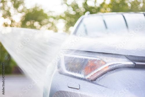 Foto A close-up view of a car's headlight being sprayed with water during a wash