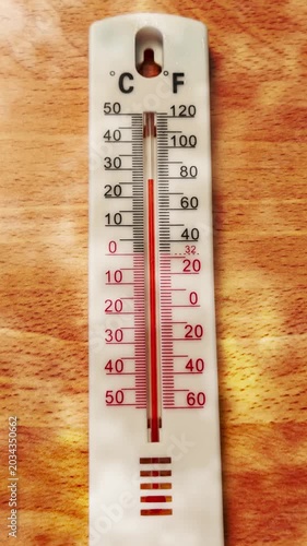 Vertical video social media - Closeup timelapse of red liquid rising up the numeric scale of a traditional celsius and fahrenheit spirit thermometer, as the ambient temperature increases.