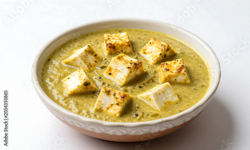 rich creamy methi malai paneer curry decorative ceramic bowl clean white studio backdrop soft diffused studio lighting