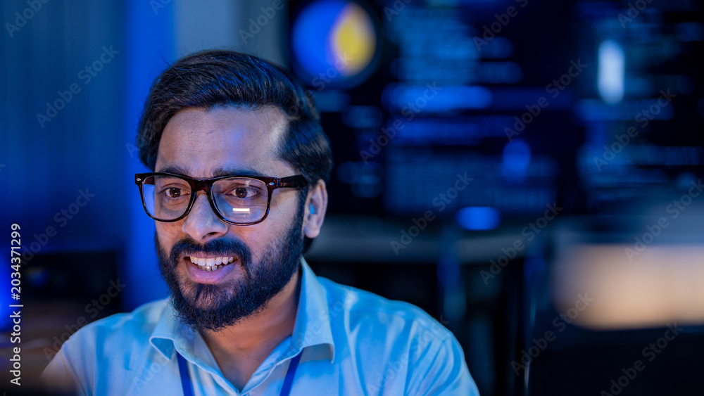 Obraz premium Focused Indian technology professional pointing at an office computer monitor to debug core processor microchip script data and hardware memory logic.
