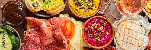 Φωτογραφία Enjoy a vibrant charcuterie board filled with assorted cheeses, savory sausages, creamy hummus, nuts, and colorful vegetables