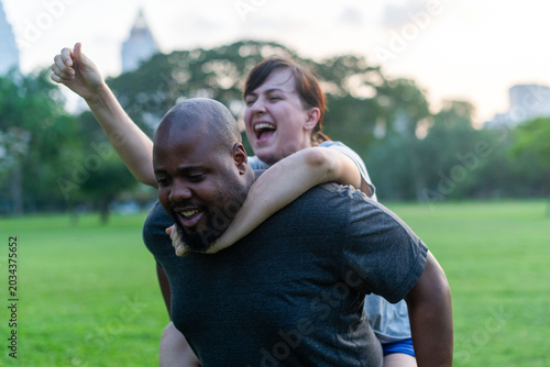 Fotografie Joyful piggyback ride in park